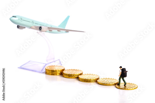 Travel Concept. Miniature travelle figure walking on pile of money coin to airplane 