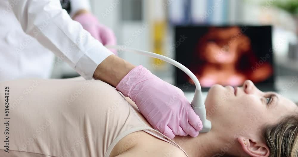 Doctor performs ultrasound of thyroid gland in clinic Doctor performs ultrasound of thyroid gland in clinic