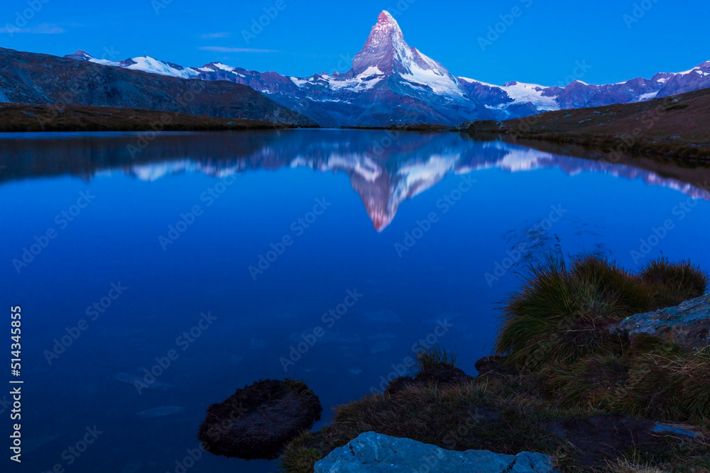 Beautiful sunset colors and cloudscape in the Swiss Alps in summer, with Matterhorn reflection in a glacier lake