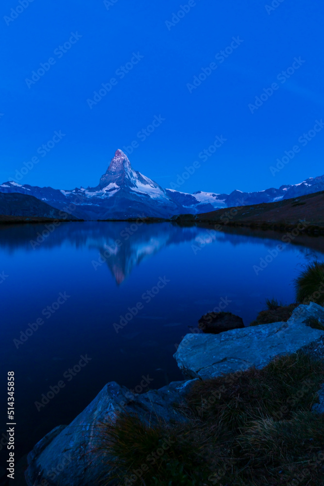 Beautiful sunset colors and cloudscape in the Swiss Alps in summer, with Matterhorn reflection in a glacier lake