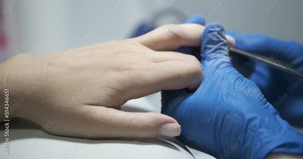Manicurist polishes client nails and varnished in salon closeup Manicurist polishes client nails and varnished in salon closeup