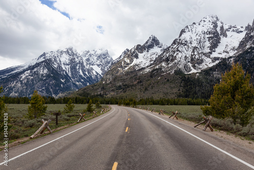 Scenic Road and Snowy Mountains in American Landscape. Spring Season. Grand Teton National Park. Wyoming, United States. Nature Background.