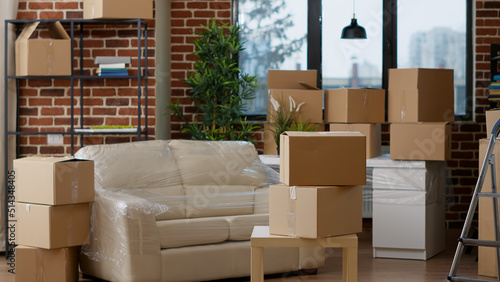 No people in empty real estate apartment with moving boxes and cardboard storage containers. Nobody in household property filled with packages and furniture for relocation decor. © DC Studio