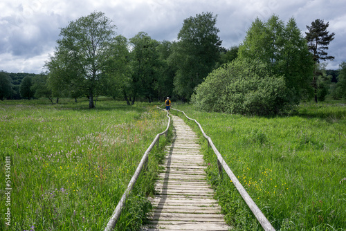 wooden path over high moor in germany with a man walking on it