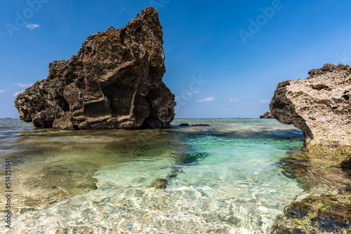 Impressive crystal clear sea water with shiny surface, natural pool between coastal rocks, sunny day on a paradise beach.