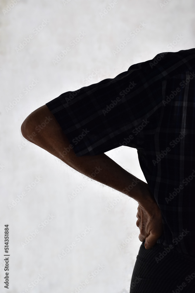 Partial silhouette image of Asian man suffering from right sided low back and loin pain. It can be caused by mechanical or pathological process.