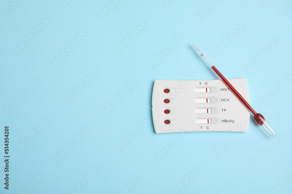 Disposable express hepatitis test kit on light blue background, flat lay. Space for text Disposable express hepatitis test kit on light blue background, flat lay. Space for text