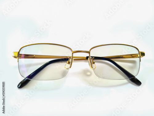 golden glasses with folded legs on a white background