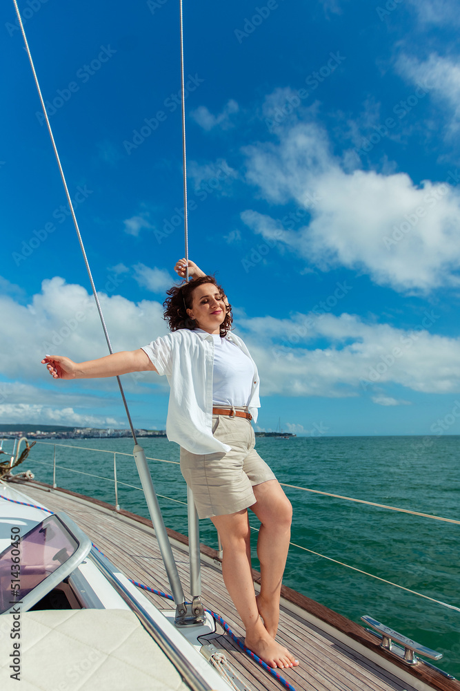 woman tourist traveler in sunglasses on a summer day on a yacht in the sea
