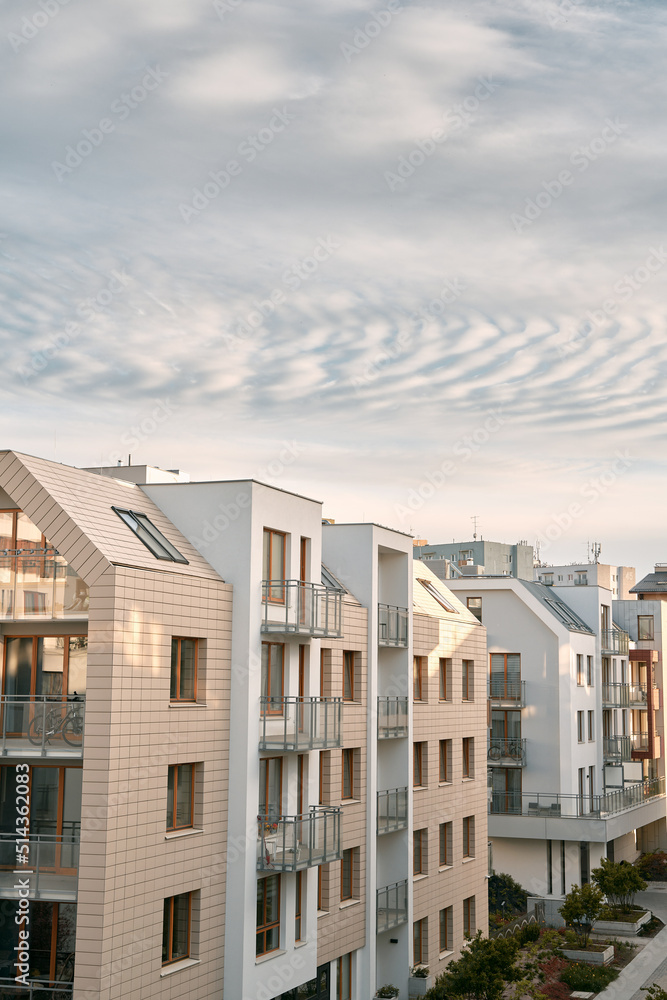 The apartment building at sunset. Condominium construction in the evening. Strong sunlight falls on the low-rise modern residential building