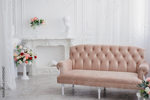 A room with white walls  a fireplace and a pink sofa