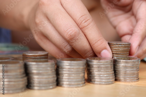 Close up of hand putting coins increase arranged on table. To convey the concepts of finance and Retirement fund.