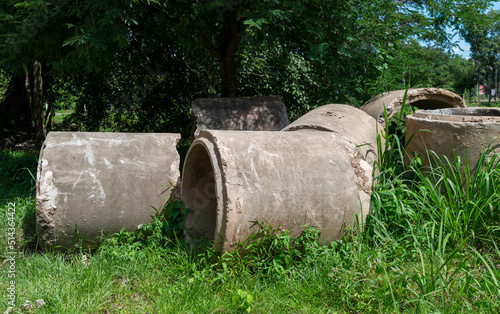 Old concrete pipes lying in the autumn grass.