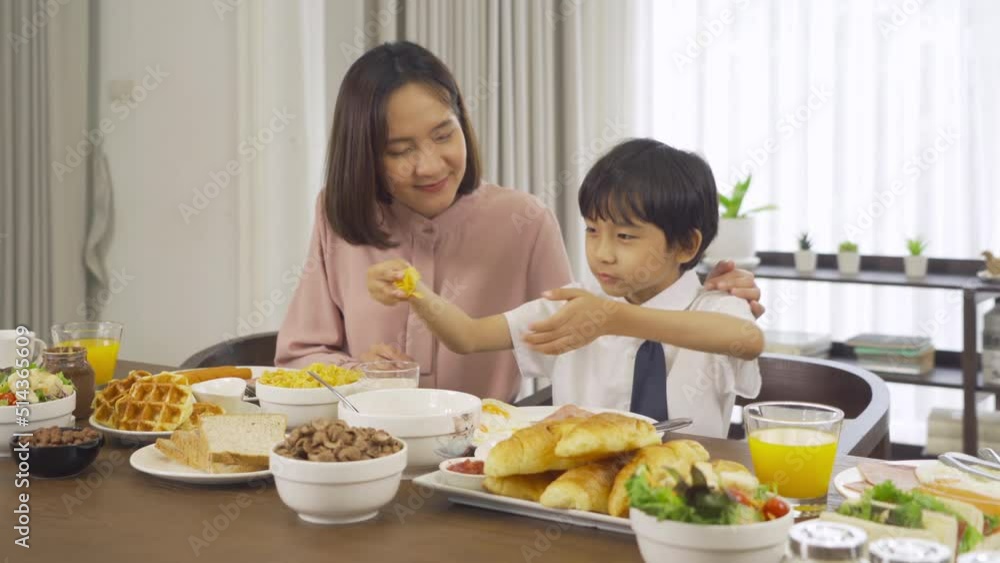 Portrait of happy smiling Asian Family eating breakfast food together before the child going to school at home. Family relationship. Love of mother, and son. People lifestyle. Portrait of happy smiling Asian Family eating breakfast food together before the child going to school at home. Family relationship. Love of mother, and son. People lifestyle.