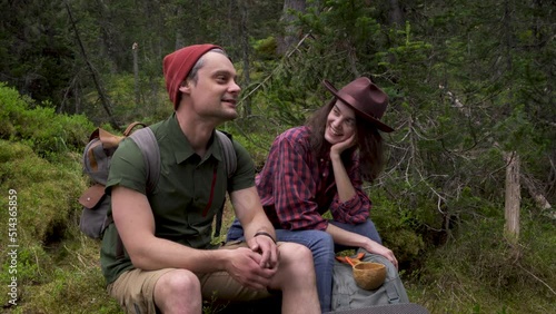 Young girl and guy hikers with backpacks on hike in forest photo