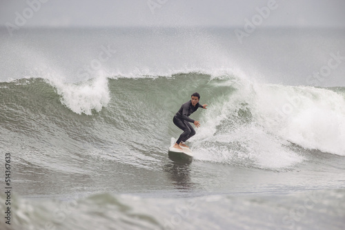 湘南の海でサーフィンを楽しむ男性 © D maborosi
