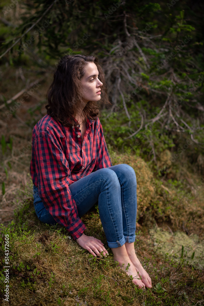 Naklejka premium Attractive young girl in hipster clothes inforest on moss posing