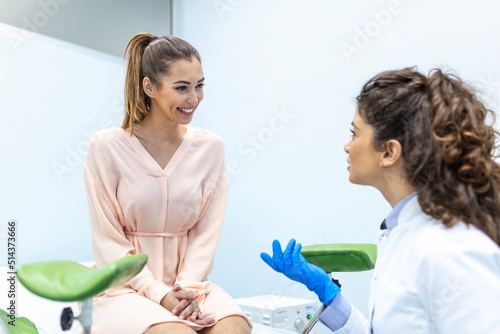 Gynecologist talking with young female patient during medical consultation in modern clinic. Patient with a gynecologist during the consultation in the gynecological office photo