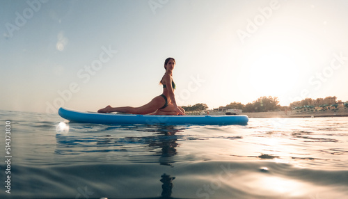 exercises on a paddle sup board in the ocean at sunrise © francescosgura