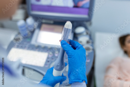 Fotografía Gynecologist places ultrasound probe cover on a transvaginal ultrasound scanner