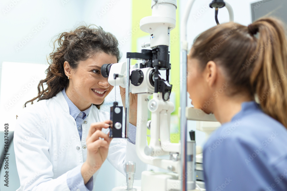 Eye doctor with female patient during an examination in modern clinic. Ophthalmologist is using special medical equipment for eye health Eye doctor with female patient during an examination in modern clinic. Ophthalmologist is using special medical equipment for eye health