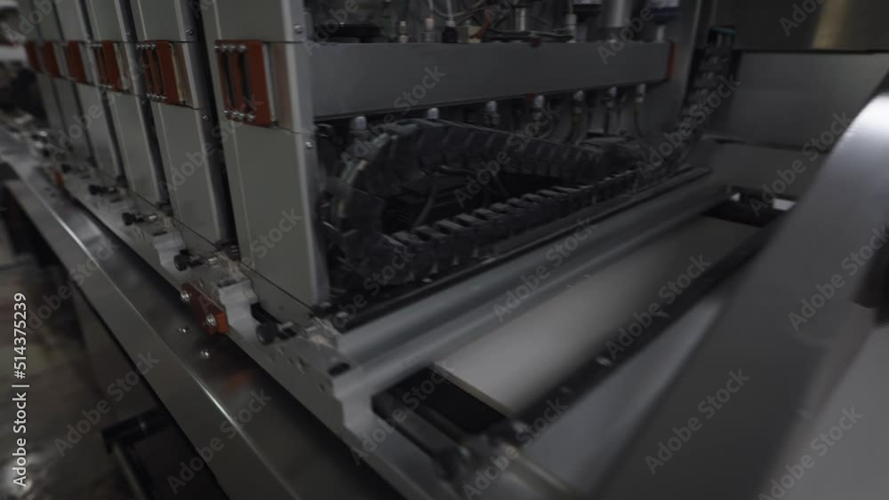 An industrial printer in a porcelain tile factory. The printer applies a pattern and texture to the board blank. An industrial printer in a porcelain tile factory. The printer applies a pattern and texture to the board blank.