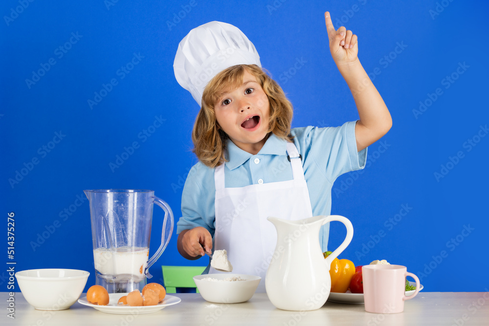 Child chef dressed cook baker apron and chef hat make food with flour isolated on studio background. Healthy nutrition kids food. Child chef dressed cook baker apron and chef hat make food with flour isolated on studio background. Healthy nutrition kids food.