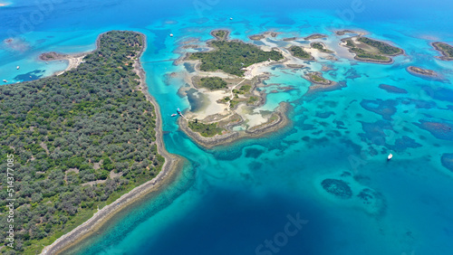 Aerial drone photo of tropical exotic volcanic island complex of Lihadonisia forming a blue lagoon and small islet of Monolia with turquoise clear organised beach, north Evia island, Greece