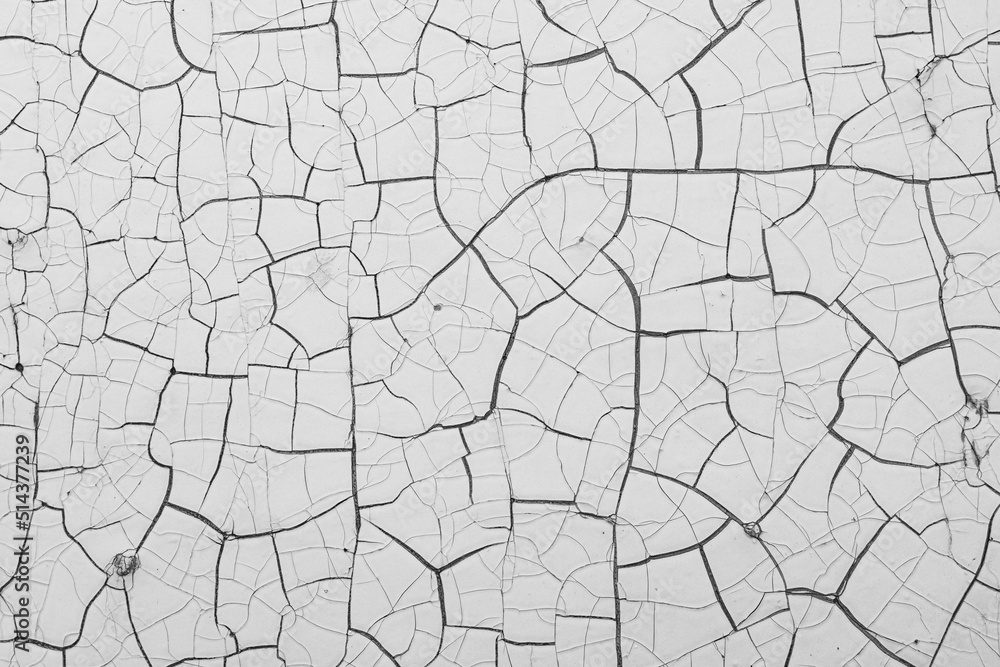 White peeling paint on the wall. Old concrete wall with cracked flaking paint. Weathered rough painted surface with patterns of cracks and peeling. High resolution texture for background and design. White peeling paint on the wall. Old concrete wall with cracked flaking paint. Weathered rough painted surface with patterns of cracks and peeling. High resolution texture for background and design.