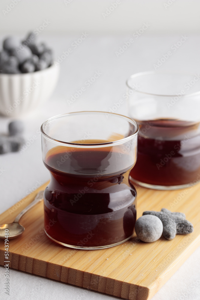 Cups of fresh coffee and a liquorice candies on white table Cups of fresh coffee and a liquorice candies on white table