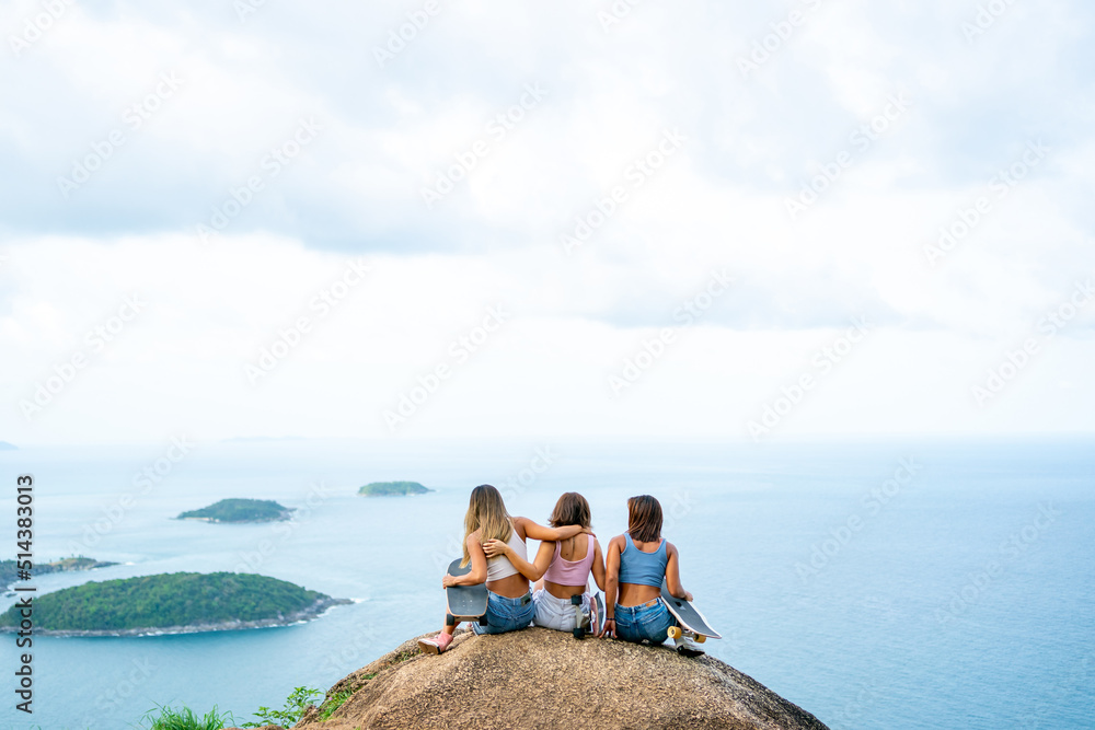 Group of Healthy Asian woman skater skating and hiking to mountain peak at tropical island on summer travel vacation. Female friends enjoy outdoor activity lifestyle adventure extreme sport together