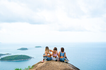 Group of Healthy Asian woman skater skating and hiking to mountain peak at tropical island on summer travel vacation. Female friends enjoy outdoor activity lifestyle adventure extreme sport together