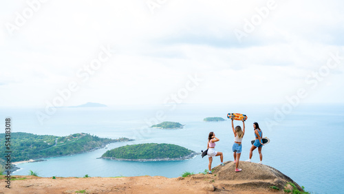 Group of Healthy Asian woman skater skating and hiking to mountain peak at tropical island on summer travel vacation. Female friends enjoy outdoor activity lifestyle adventure extreme sport together