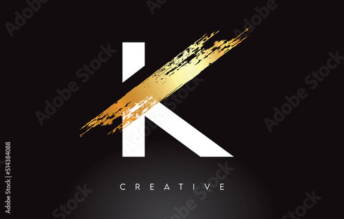 Golden K Letter Logo with Brush Stroke Artistic Look on Black Background Vector