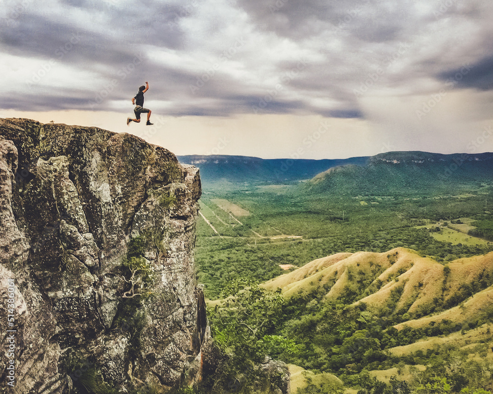 Homem saltando na beira do abismo, no alto de montanha. Foto no Morro do segredo, em lajeado, Tocantins 
