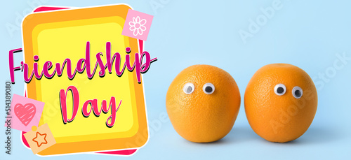 Funny oranges and text FRIENDSHIP DAY on light blue background