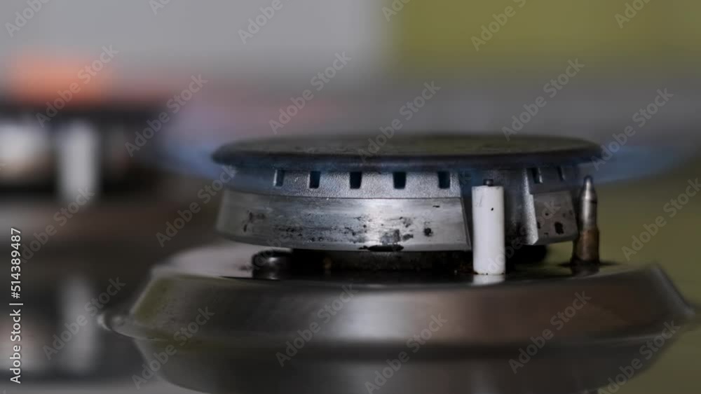 Fire in the gas burner is lit in slowmo. The flame of an electric