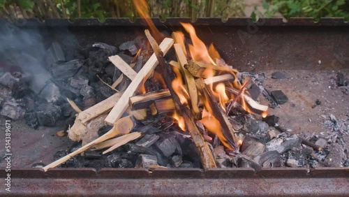 Chips and charcoal for barbecue are burning in the grill.
