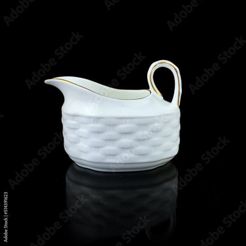 white antique milk jug with gold pattern. retro vessel for milk. coffee service. vintage gravy boat