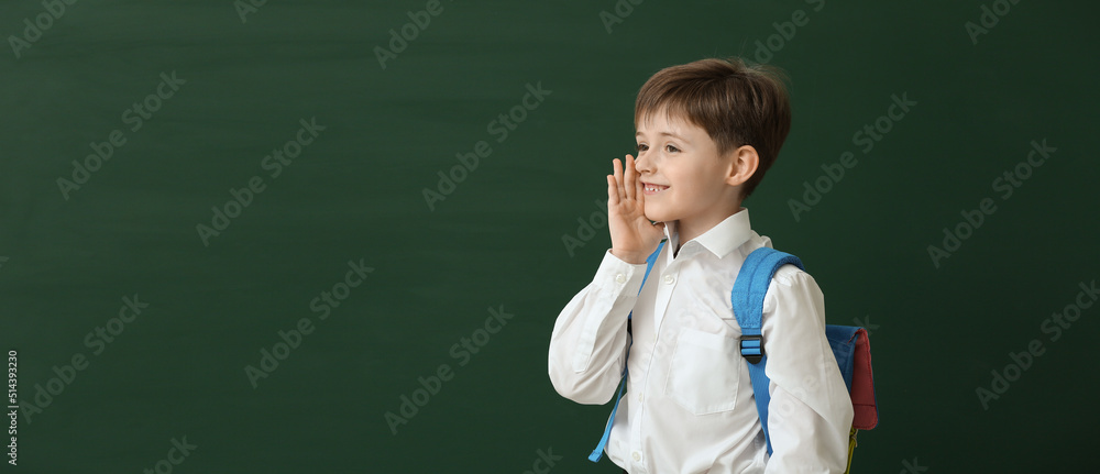 Little schoolboy on color background with space for text