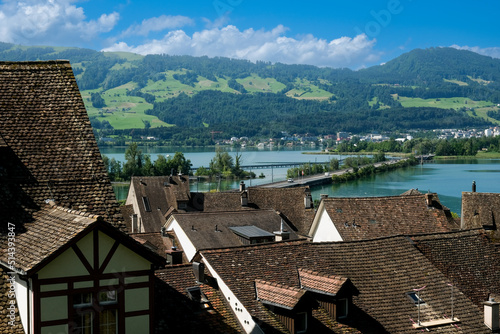 A picture of houses roof in Rapperswil old town with lake and bridge insight. photo