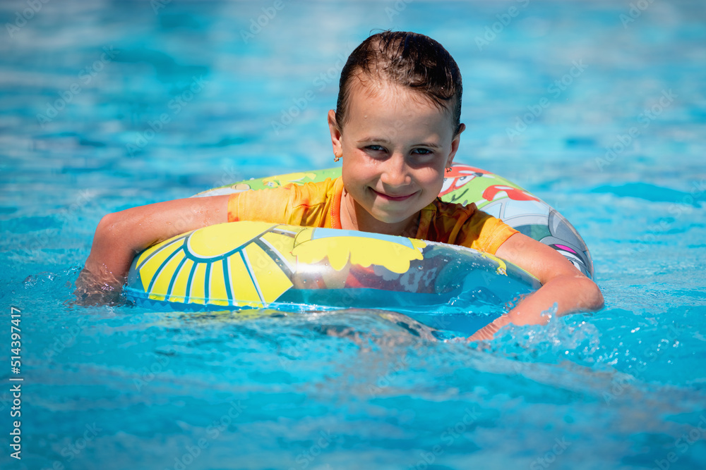 Happy kid have fun in the pool. Joyful child girl on inflatable ring ...