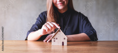 Photo Closeup image of a woman holding and showing wooden house model