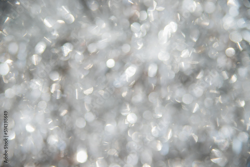Blurred background of silver tinsel. Holiday decorations. Christmas background. The texture of sequins and shimmers, reflection. Abstract background.