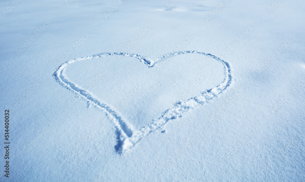 Love winter vacation concept heart drawn in the snow top view