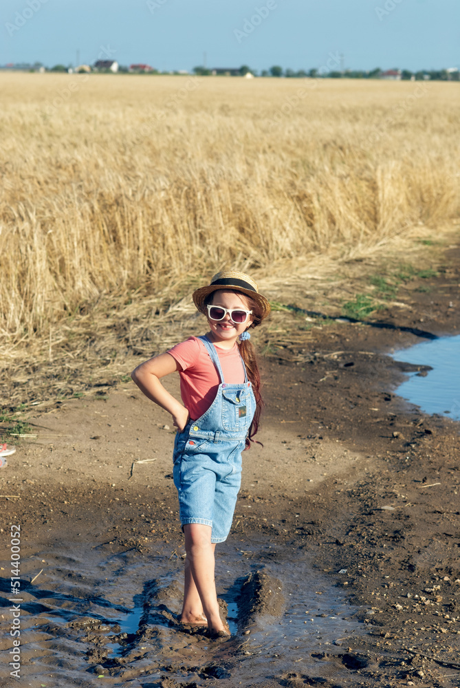 Happy child walking barefoot on a dirt road