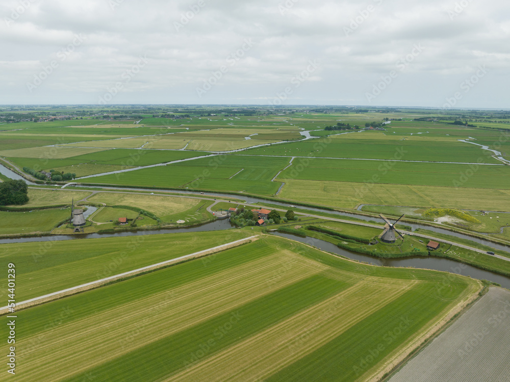 Historic traditional typical dutch old windmills mills on the rural countryside in green nature grass field farm landscape with a river sunny weather. Tourist attraction. Historic traditional typical dutch old windmills mills on the rural countryside in green nature grass field farm landscape with a river sunny weather. Tourist attraction.