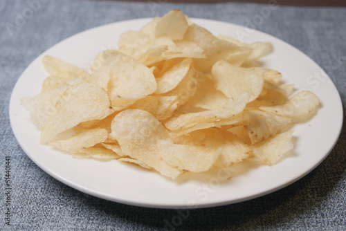 Bowl with tasty potato chips on wooden background .