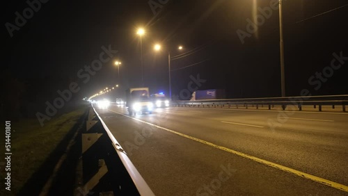 Trucks, cars drive at night on the road.