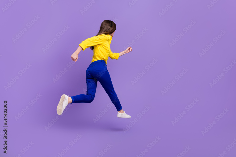 Full length body size view of attractive energetic girl jumping running fast isolated over bright violet purple color background Full length body size view of attractive energetic girl jumping running fast isolated over bright violet purple color background